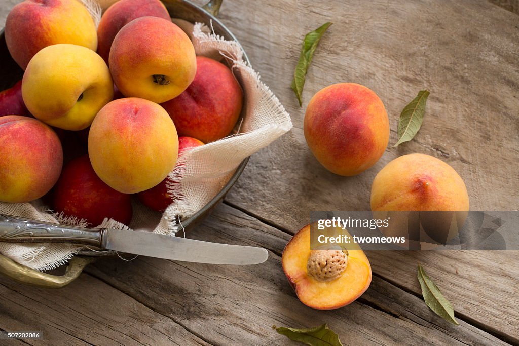 Peaches on moody rustic wooden kitchen table top background.