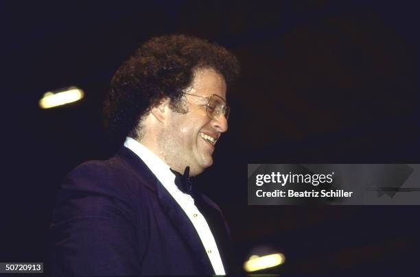 Music dir. & conductor James Levine smiling down on the orchestra as he stand on podium before the start of a performance at the Metropolitan Opera.