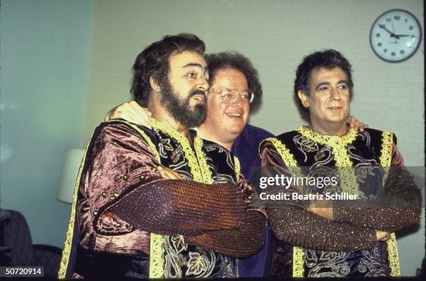 Tenors Luciano Pavarotti & Placido Domingo, both in costume for the role of Manrico in Il Trovatore posing w. Music dir. & conductor James Levine...