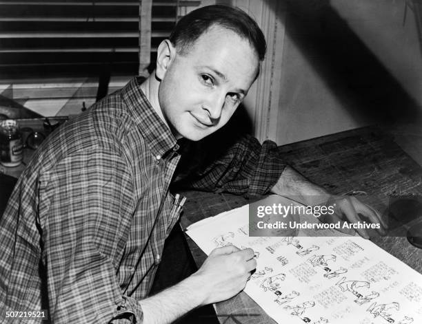 Cartoonist, author, playwright and Pulitzer Prize winner Jules Feiffer working on proof sheets from his first book, 'Sick, Sick, Sick', New York, New...