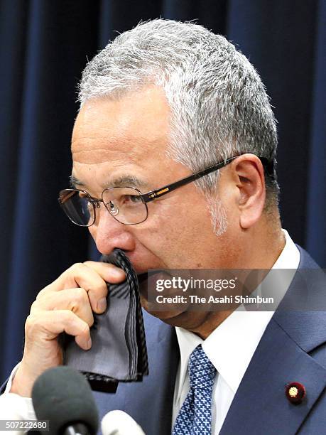 Economy minister Akira Amari wipes his face during a news conference announcing his resignation on January 28, 2016 in Tokyo, Japan. Amari announced...