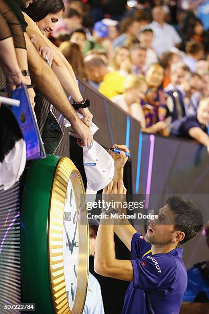 Novak Djokovic of Serbia signs autographs after winning in his semi final match against Roger Federer of Switzerland during day 11 of the 2016...