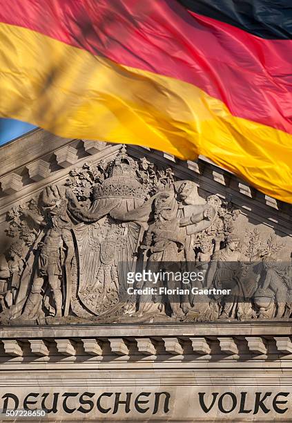 German national flag blows in the wind in front of the Reichstag and the lettering 'Deutschen Volke' on January 28, 2016 in Berlin.