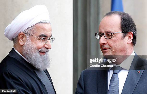 French President Francois Hollande welcomes Iranian President Hassan Rouhani prior to attend a meeting at the Elysee Presidential Palace on January...