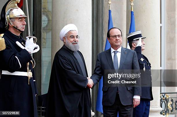 French President Francois Hollande welcomes Iranian President Hassan Rouhani prior to attend a meeting at the Elysee Presidential Palace on January...