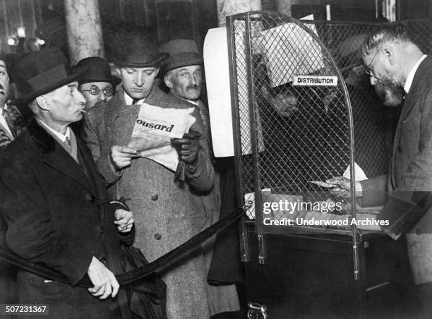 Parisians waiting to bet at the newly introduced public Pari-Mutuel bureaus where betters can bet safely on the horses, Paris, France, late 1920s.