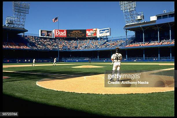 Detroit Tigers Mickey Tettleton at HP as players take field at Tiger Stadium.; Wide angle view of field, OF stands and scoreboard from behind HP;