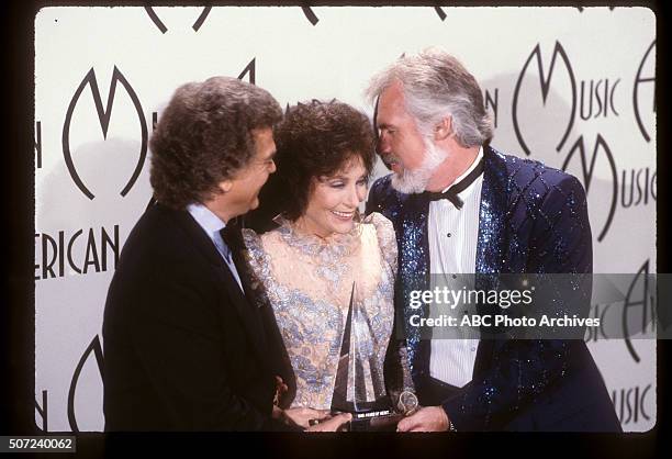 Backstage Coverage - Airdate: January 28, 1985. LORETTA LYNN, RECIPIENT AWARD OF MERIT WITH PRESENTERS CONWAY TWITTY AND KENNY ROGERS