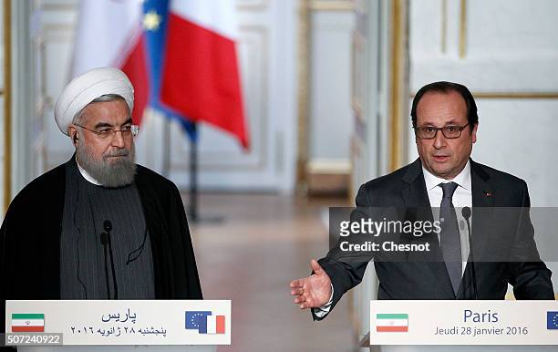French President Francois Hollande delivers a speech next to Iranian President Hassan Rouhani during a press conference at the Elysee Presidential...