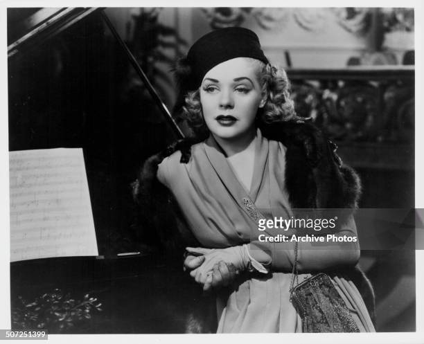 Actress Alice Faye, leaning against a piano wearing a mink stole, in a scene from the movie 'Alexander's Ragtime Band', 1938.