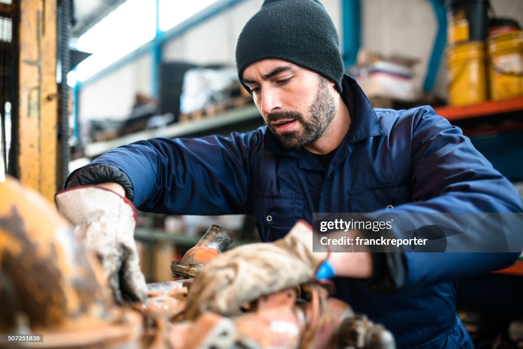 Mechanic working in a workshop on a truck engine