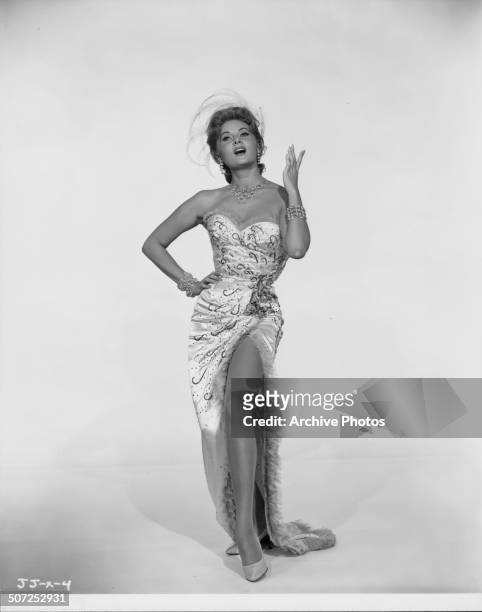 Portrait of actress Rhonda Fleming wearing an evening dress with a thigh-high split, as she appears in the movie 'Alias Jesse James', 1959.