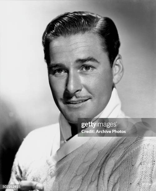 Portrait of actor Errol Flynn wearing a cable knit sweater, circa 1935.