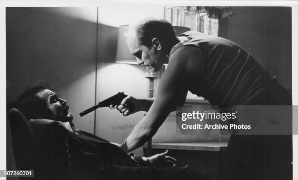 Actor Robert Duvall as Earl Macklin, pointing a gun at Felice Orlandi as Frank Orlandi, in a scene from the film "The Outfit", 1973.