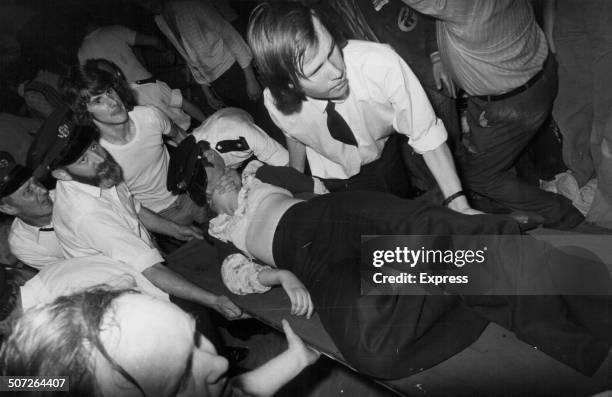 Ambulance paramedic Terry Wing, giving a teenage girl the kiss of life as she is carried on a stretcher, following a crowd incident at a David...