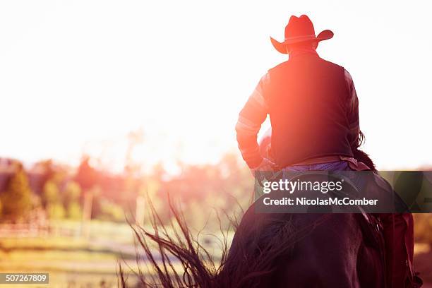 cowboy riding away rear view - montana ranch stock pictures, royalty-free photos & images