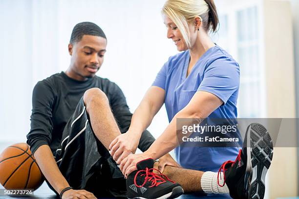 basketball player getting physical therapy - checking sports stock pictures, royalty-free photos & images