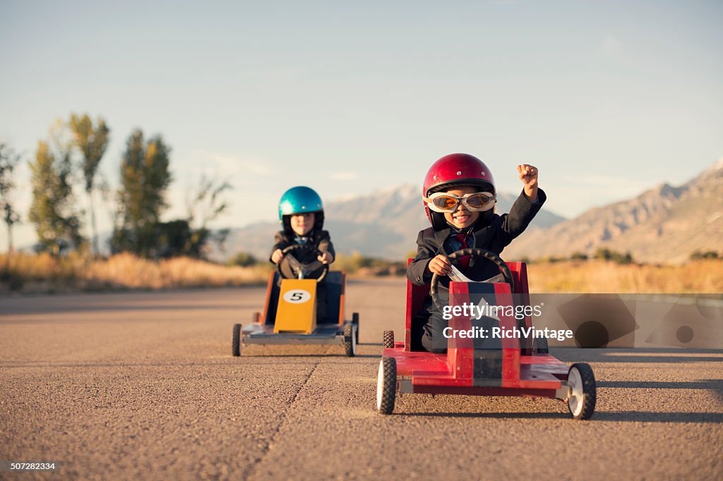 Junge Business-Jungen in Anzügen Rennen Spielzeug-Autos