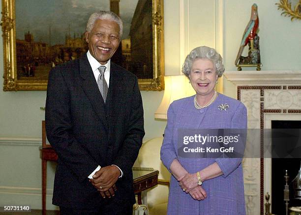 Former South African President Nelson Mandela joins English Queen Elizabeth II for tea at Buckingham Palace.