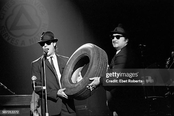 Dan Aykroyd and John Belushi holding a tyre and performing with The Blues Brothers at the Palladium in New York City on June 1, 1980.