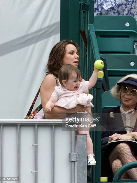 John McEnroe's daughter, Ava, throughs dad a tennis ball during the match at charity tennis event at Buckingham Palace for the National Society for...