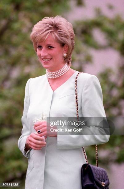 England's Princess Diana in white w. Pearl choker, on the first day of her visit to Chicago, arriving at Northwestern University.