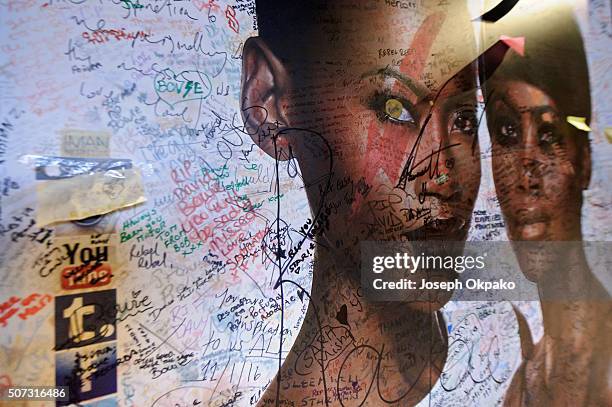 Graffiti and other writings cover a nearby commercial billboard two weeks after the death of Brixton born English singer, songwriter David Bowie at...