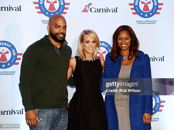 Country superstar Carrie Underwood, center, poses for a photograph with Operation Homefront recipient U.S. Navy Petty Officer Second Class Andrew...