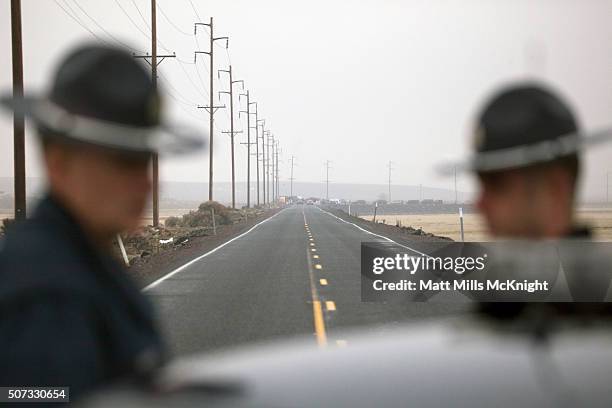 Oregon State Troopers block a road entering the Malheur National Wildlife headquarters, as a large group of law enforcement officials congregate at a...