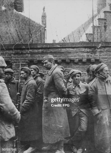 Group of British prisoners of war guarded by a German soldier, during World War Two, circa 1943.