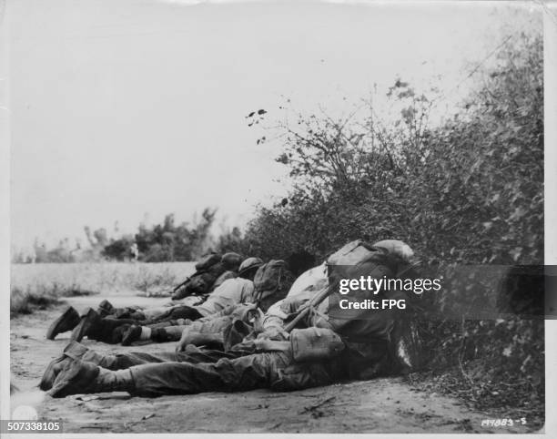 Troops and Filipino guerrillas pinned down by enemy in Bamban during World War Two, Luzon Island, Philippines, circa 1943.