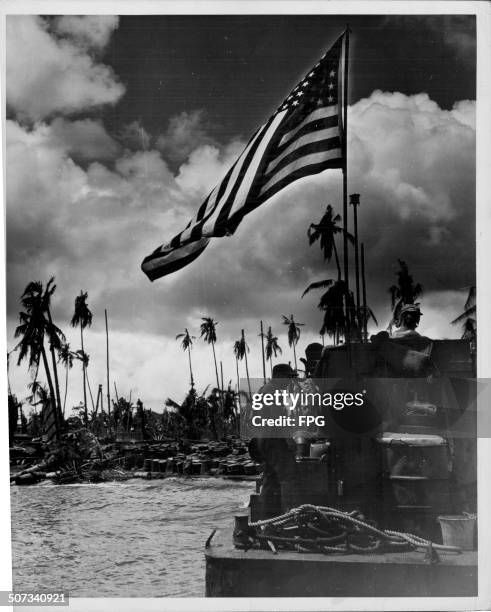 Coast Guards flying the American flag at a beachhead during World War Two, Leyte Island, Philippines, circa 1943.