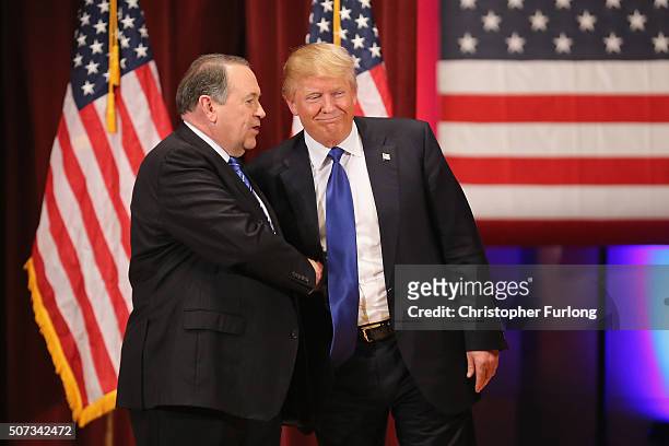 Republican presidential candidate Donald Trump and rival candidate Mike Huckabee shake hands during the rally for veterans at Drake University on...