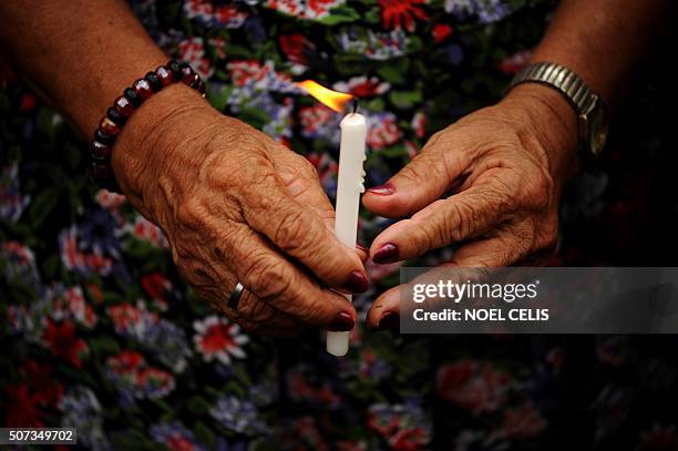 Filipina "comfort woman", a sex slave for the Japanese Imperial Army during World War II, holds a lit candles for the women who have died over the...