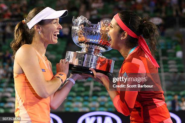 Martina Hingis of Switzerland and Sania Mirza of India pose with the championship trophy after winning their women's doubles final match against...