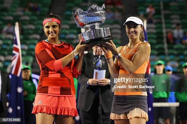 Martina Hingis of Switzerland and Sania Mirza of India pose with the championship trophy after winning their women's doubles final match against...