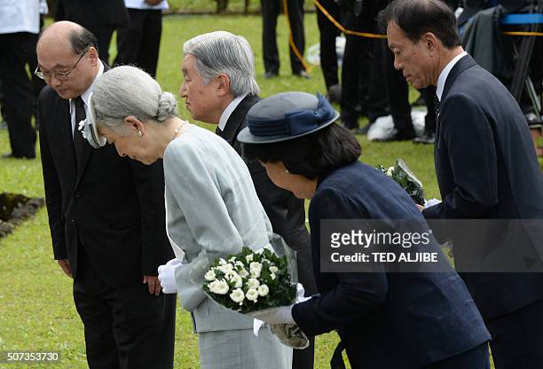 Japan's Emperor Akihito and his wife Empress Michiko prepare to offer flowers during a visit to a Japanese memorial garden for Japanese soldiers...