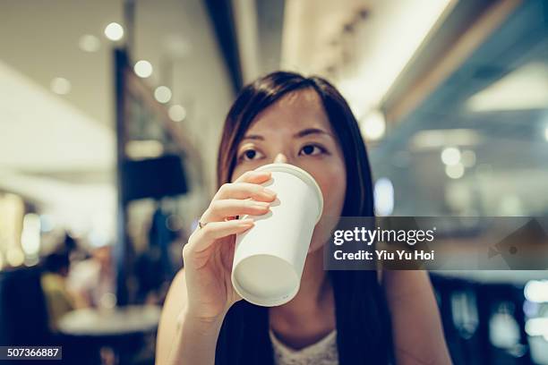 young lady drinking coffee at a cafe - plastikbecher stock-fotos und bilder