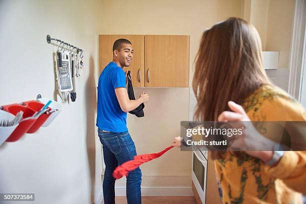 two flatmates goofing around - women whipping men 個照片及圖片檔