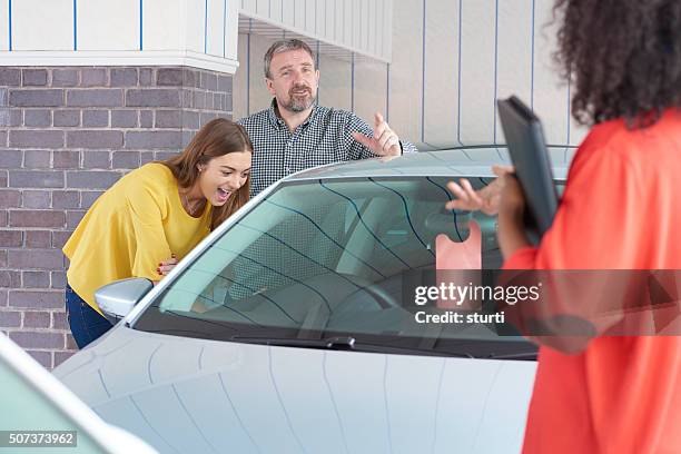 dad buying a second hand car for his daughter - tweedehands autoverkoop stockfoto's en -beelden