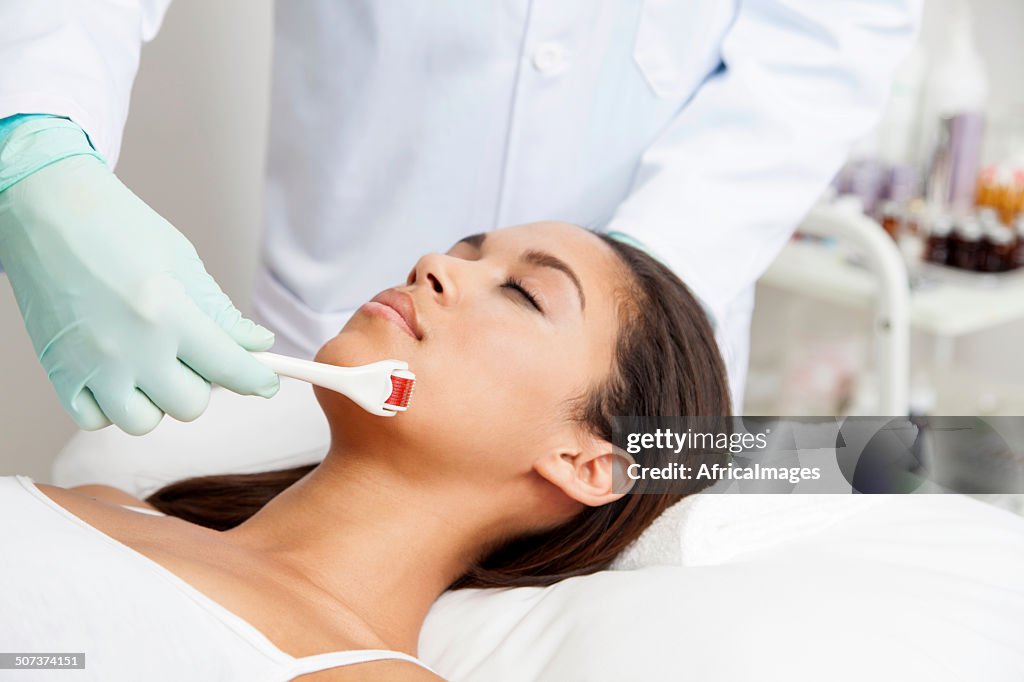 African patient getting micro-needling treatment by her doctor