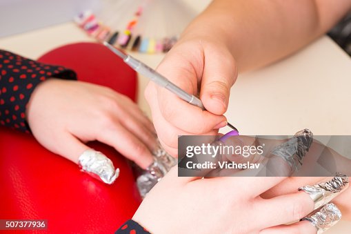 Manicurist Shaping Finger Nails with Tool in Spa Manicurist Shaping Finger Nails with Tool in Spa