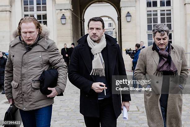 Jerome Kerviel, former trader for Societe Generale SA, center, holds a cigarette as he leaves Versailles courthouse with Benoit Pruvost, a lawyer,...