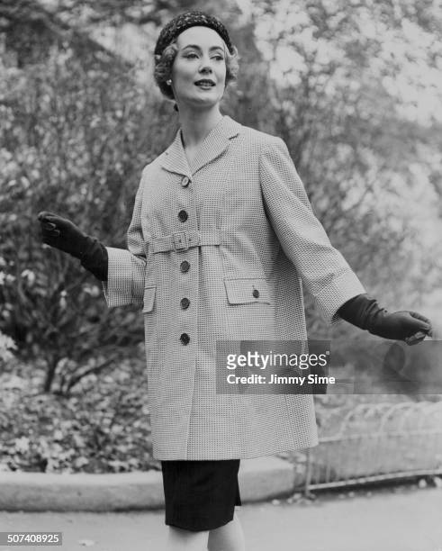 Pat O'Reilly models a car coat in navy and white cotton pique, at Burberry's show of rainwear coats at the Savoy Hotel, London, November 4th 1958.