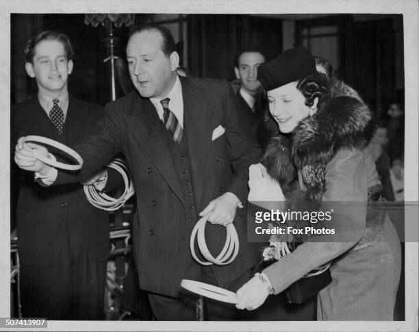 Actor Cecil Parker and his wife Lady Parker, playing a hoop-la game at the United Charities Christmas Fair, December 6th 1939.