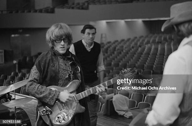 Guitarist Paul Kantner of the rock group Jefferson Airplane rehearses for a concert as promoter Bill Graham looks on at Hunter College in New York...