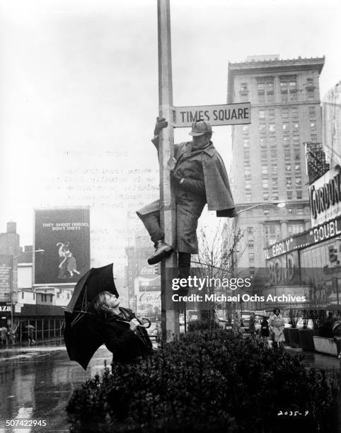 George C. Scott dressed as Sherlock Holmes climbs a pole as Joanne Woodward his psychiatrist watches him as they seeks clues for the man who is...