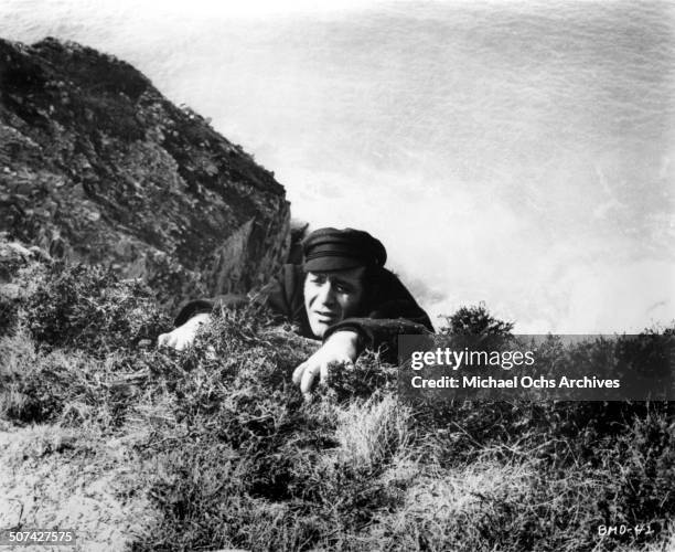 Jean Yanne tries not to fall over a cliff in a scene from the movie "This Man Must Die" , circa 1969.