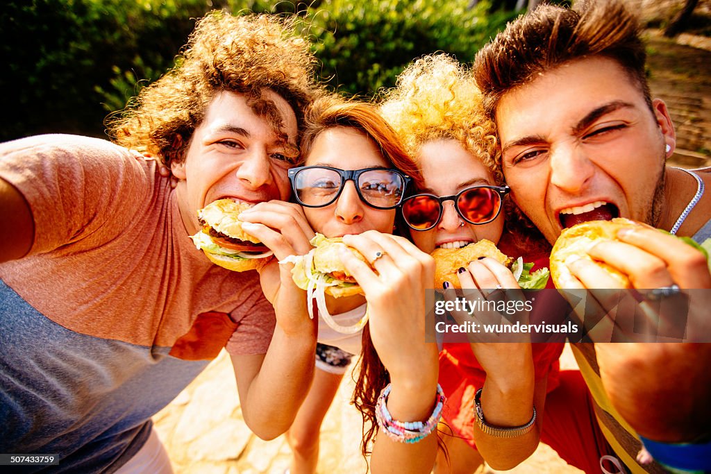 Amigos tomando autofoto con hamburguesas