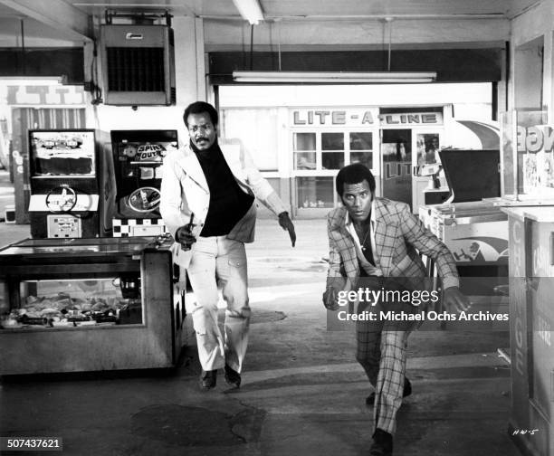 Jim Brown as Jimmy Lait and Fred Williamson pursue members of a mysterious organization plotting mass murder in a scene from the movie"Three the Hard...